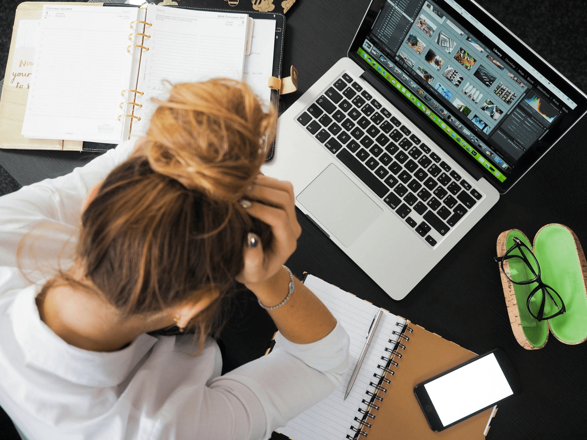 Woman sitting at a desk, focused on her MacBook, symbolizing copywriting services and the work they do.