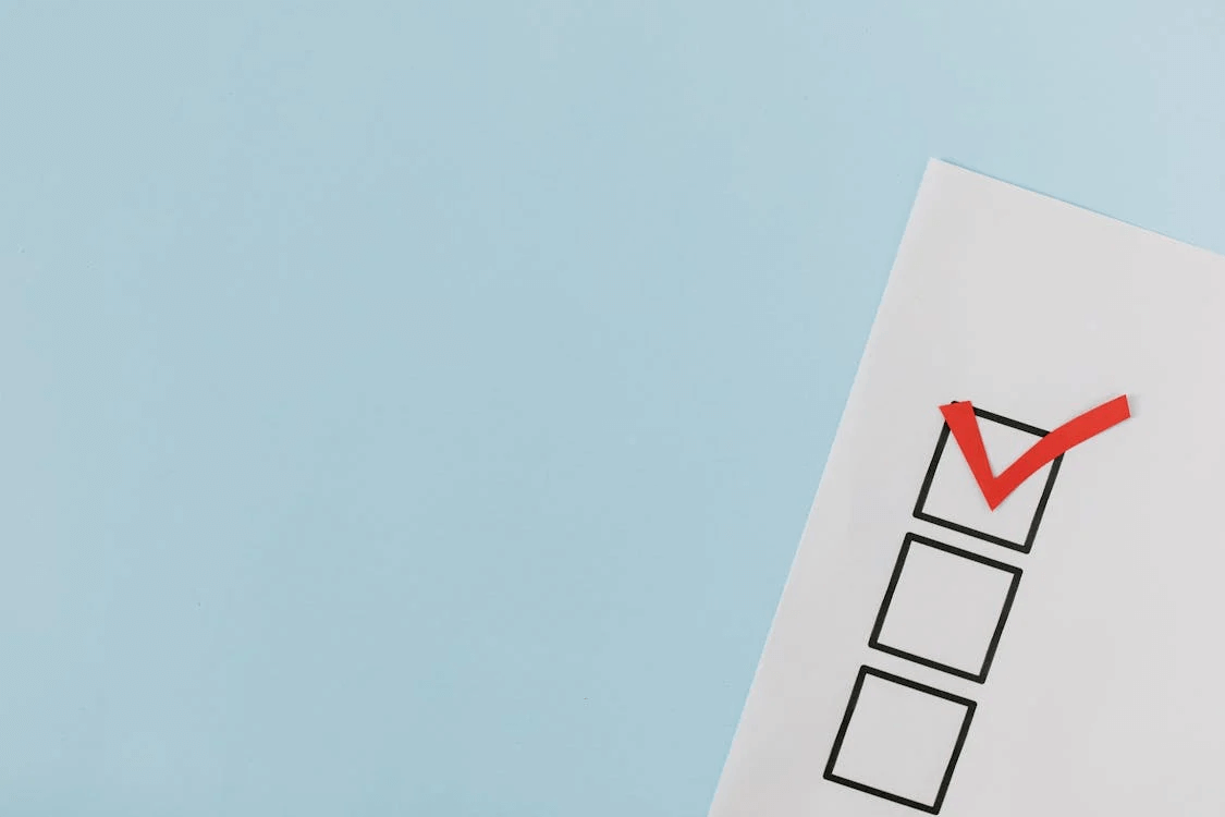 A close-up of a red checkmark in a box, representing the essential checklist for launching a small business website.