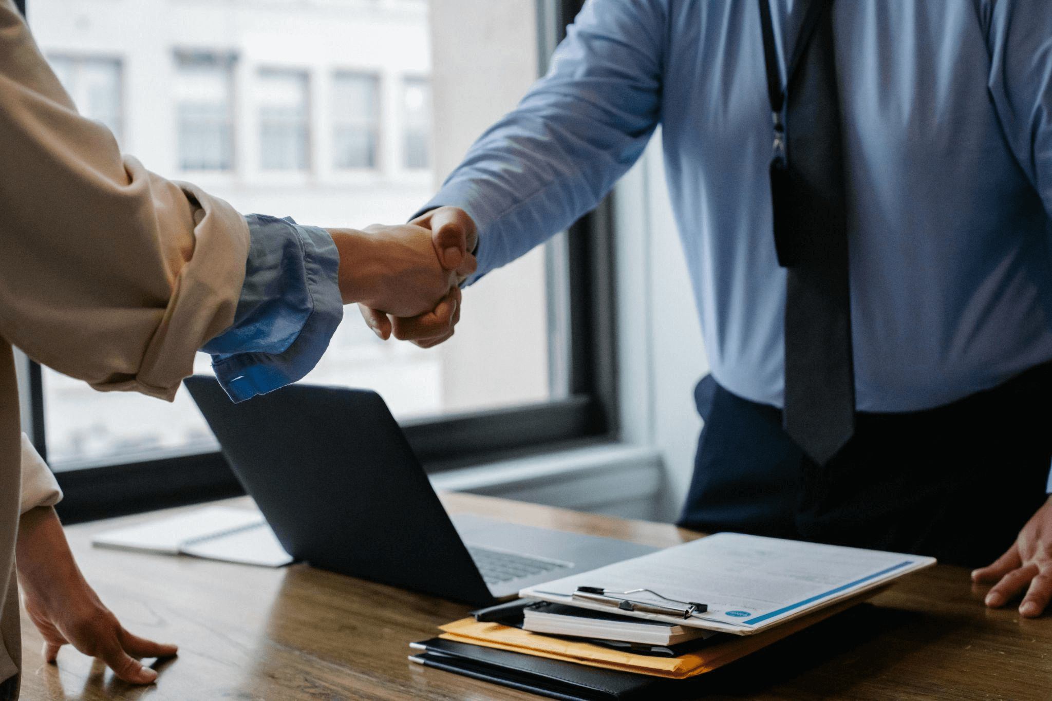 An investor shakes hands with ab business owner after reading their business plan