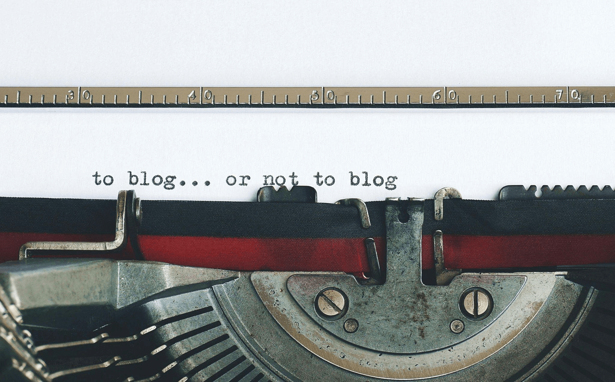 A vintage typewriter with the text “to blog, or not to blog