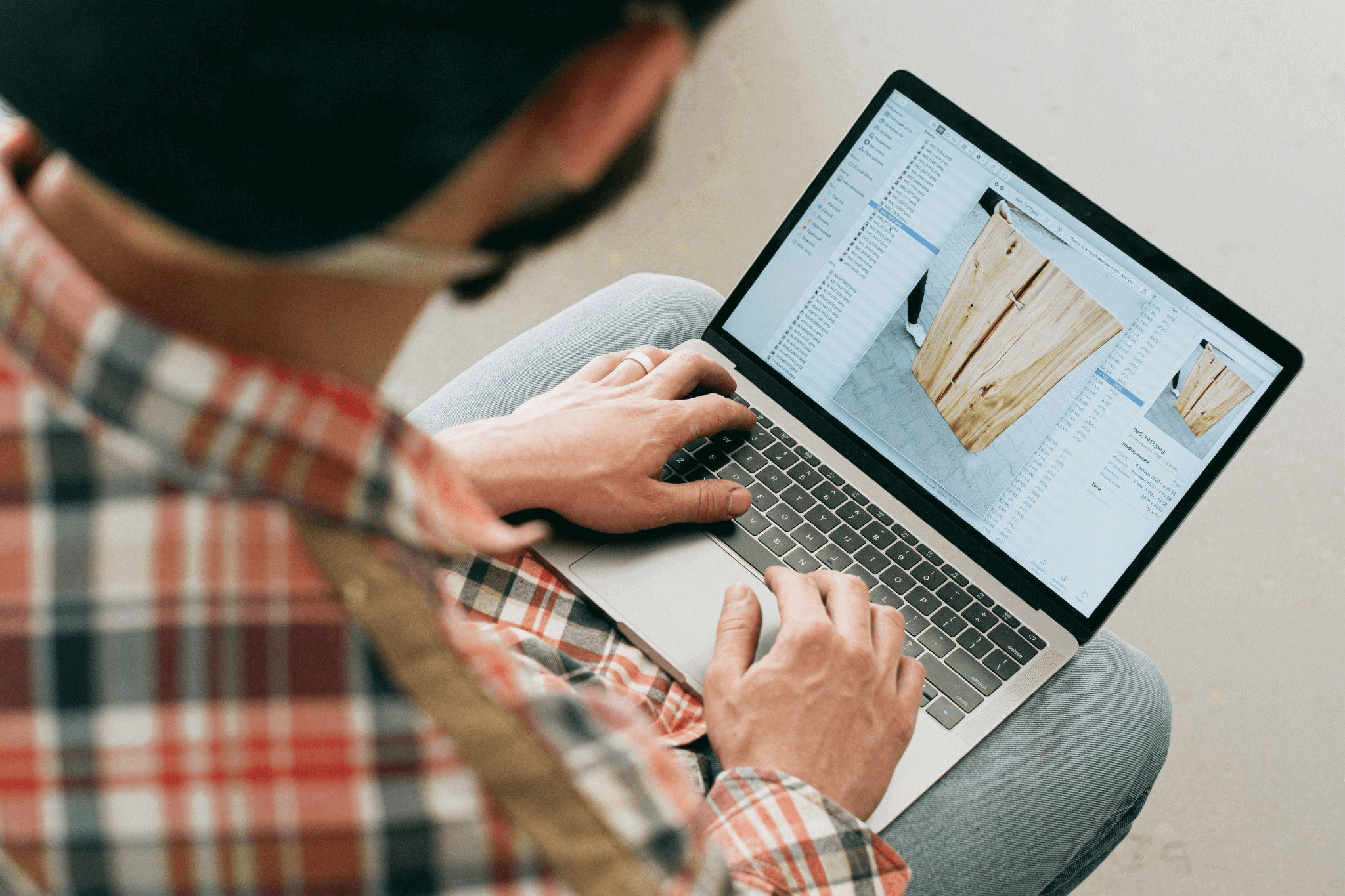 A product description writer working on a MacBook Air, crafting compelling copy while seated comfortably on a couch.