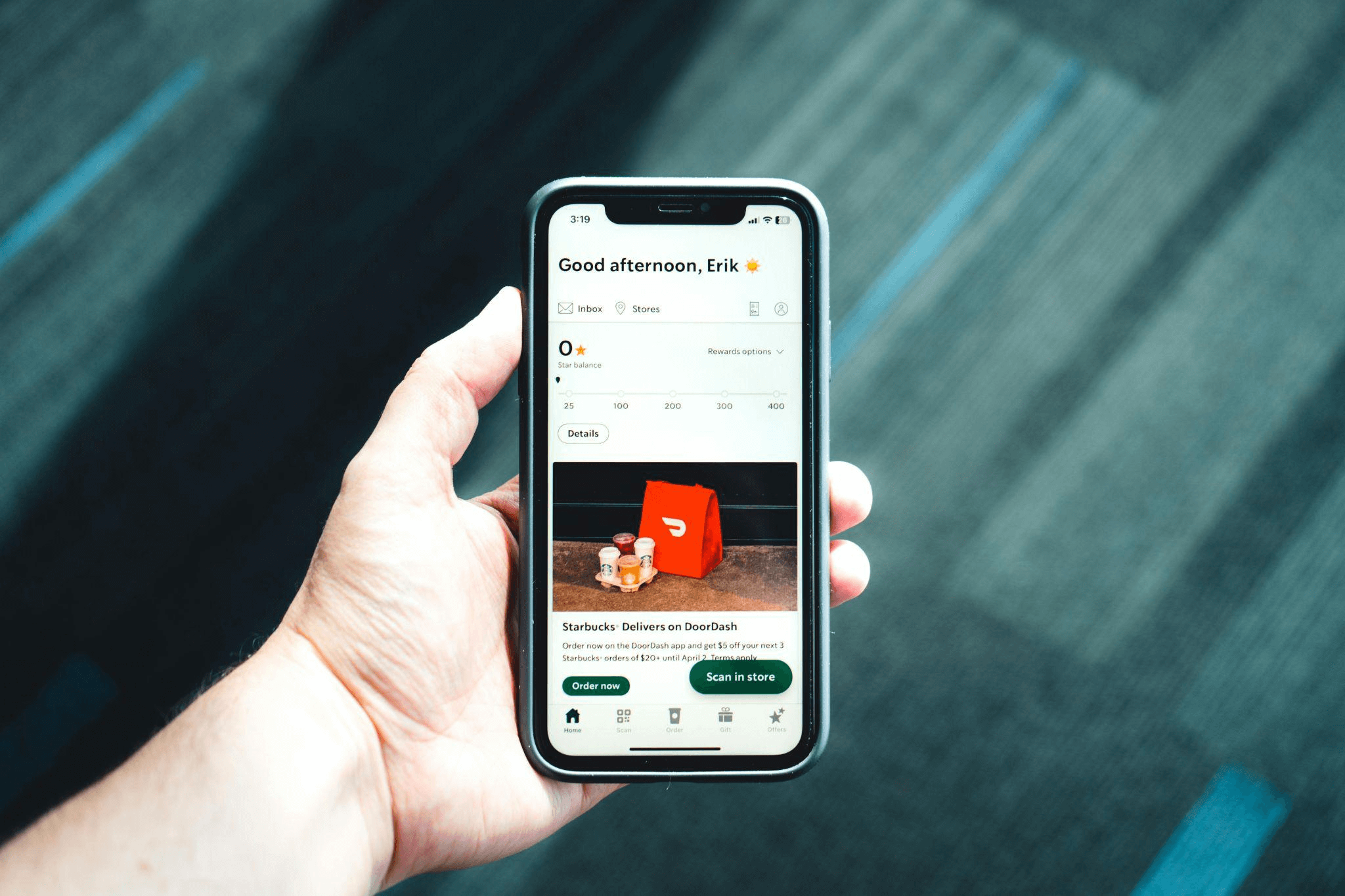 Hand holding a phone with a delivery app open, showcasing post-purchase communication techniques recommended by a copywriting agency.