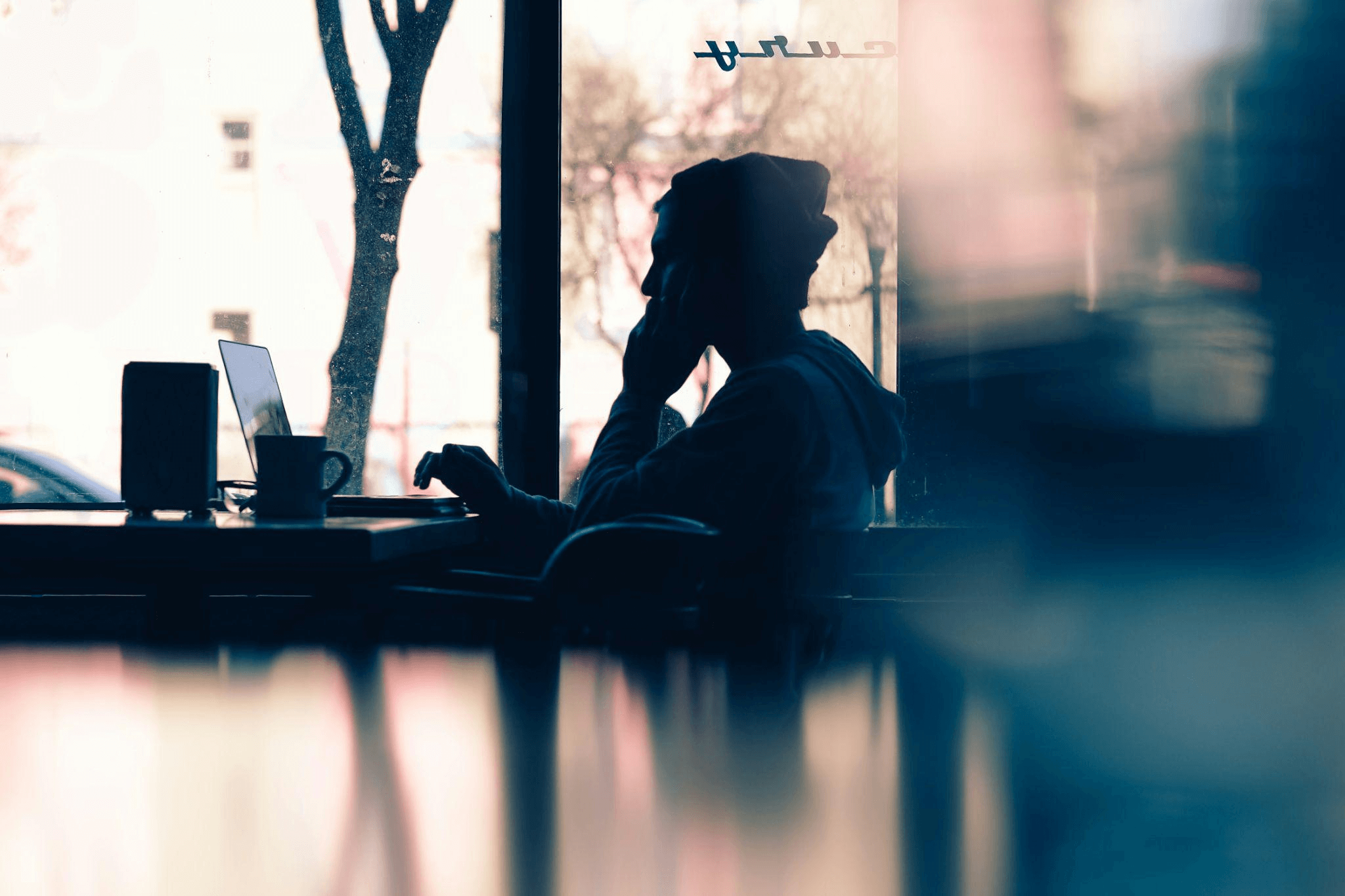 Silhouette of a person working on a laptop, symbolizing the efficiency and focus achieved through blog management services.