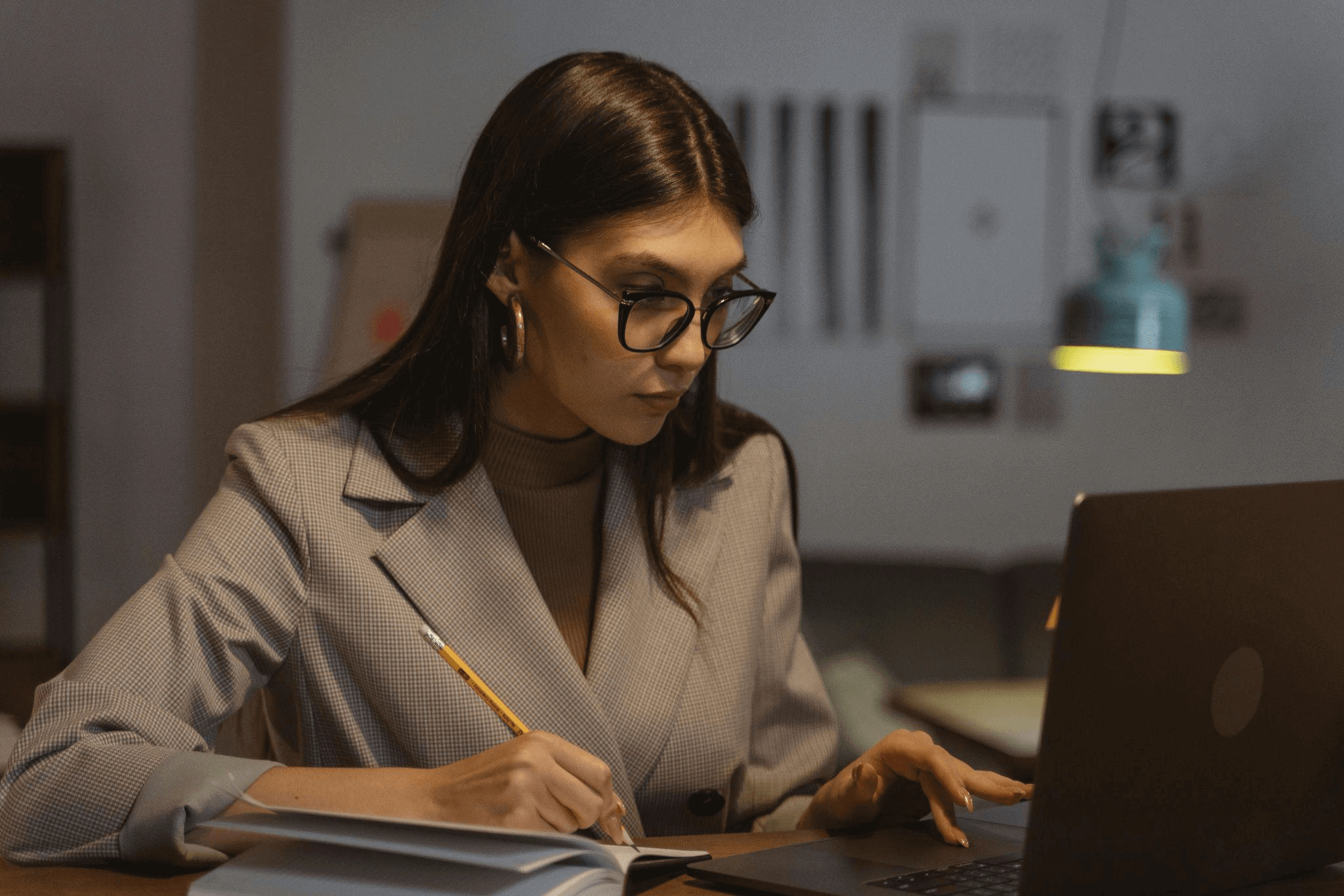 Professional woman in a gray blazer working on a laptop, symbolizing the expertise offered by a biography writing service.