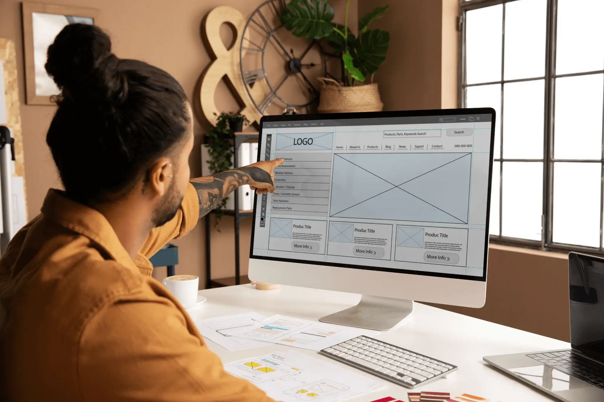 A man at a desk working on design plans and strategies, illustrating the concept of landing page optimization.